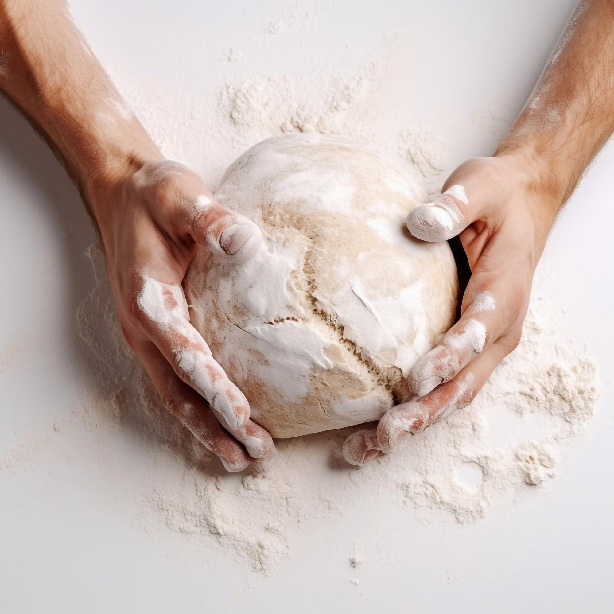 Hands kneading dough in workshop